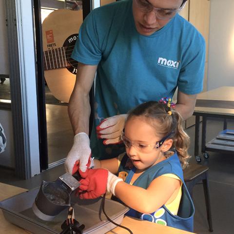 apprentice works with a child at MOXI
