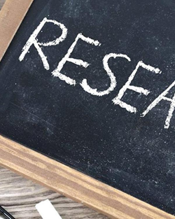 slate with research written on it